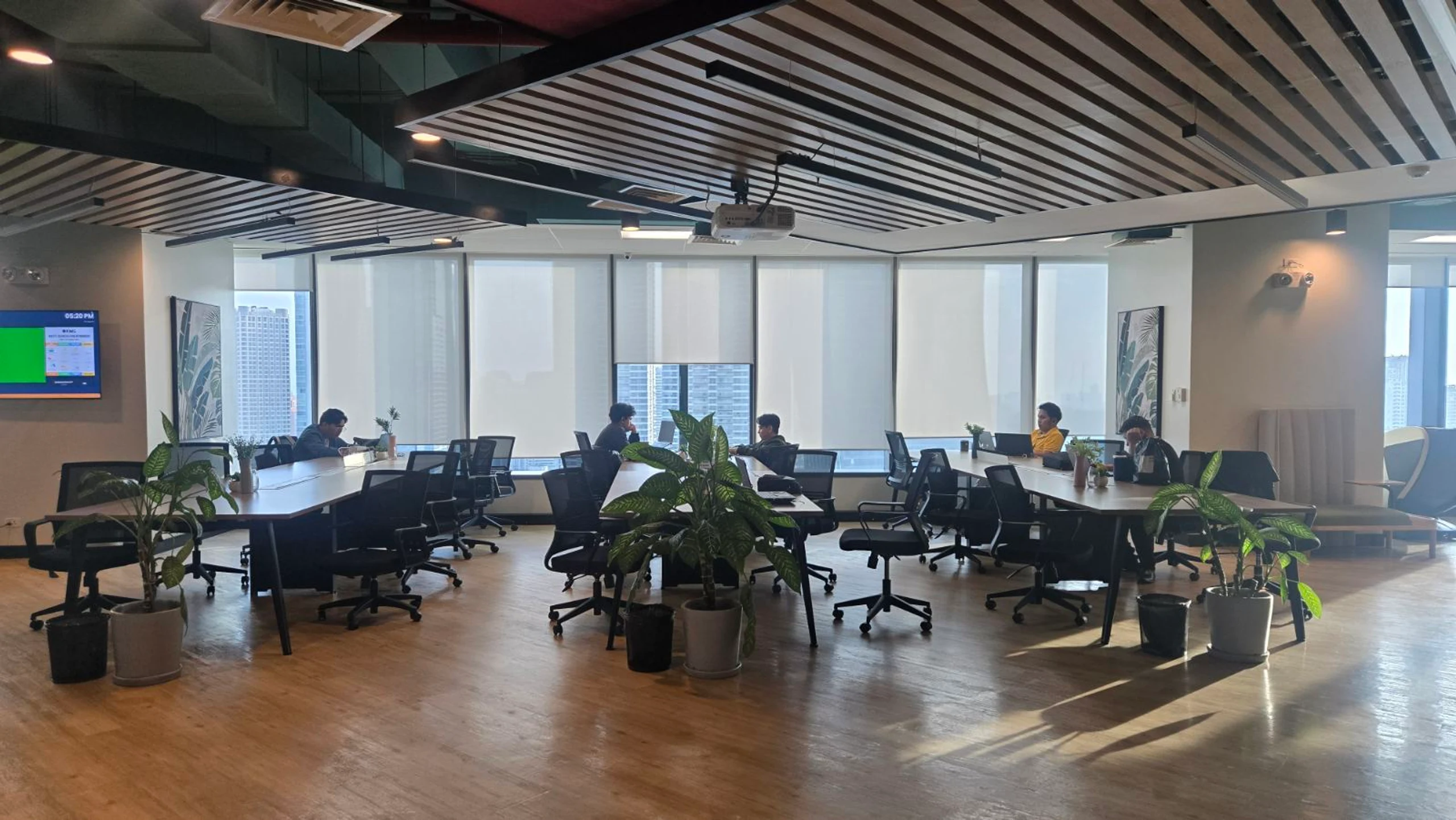 Team members working at shared tables in an open collaborative office space